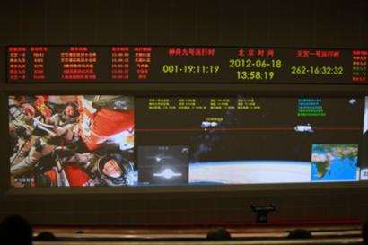 6月18日拍摄的北京航天飞控中心ＤＬＰ大屏幕显示的神九飞船与天宫一号交会对接的画面